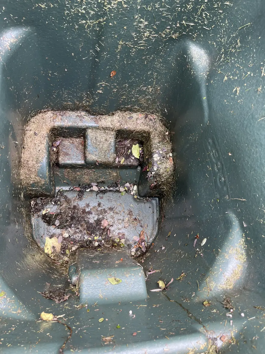 Debris-covered green bin before cleaning